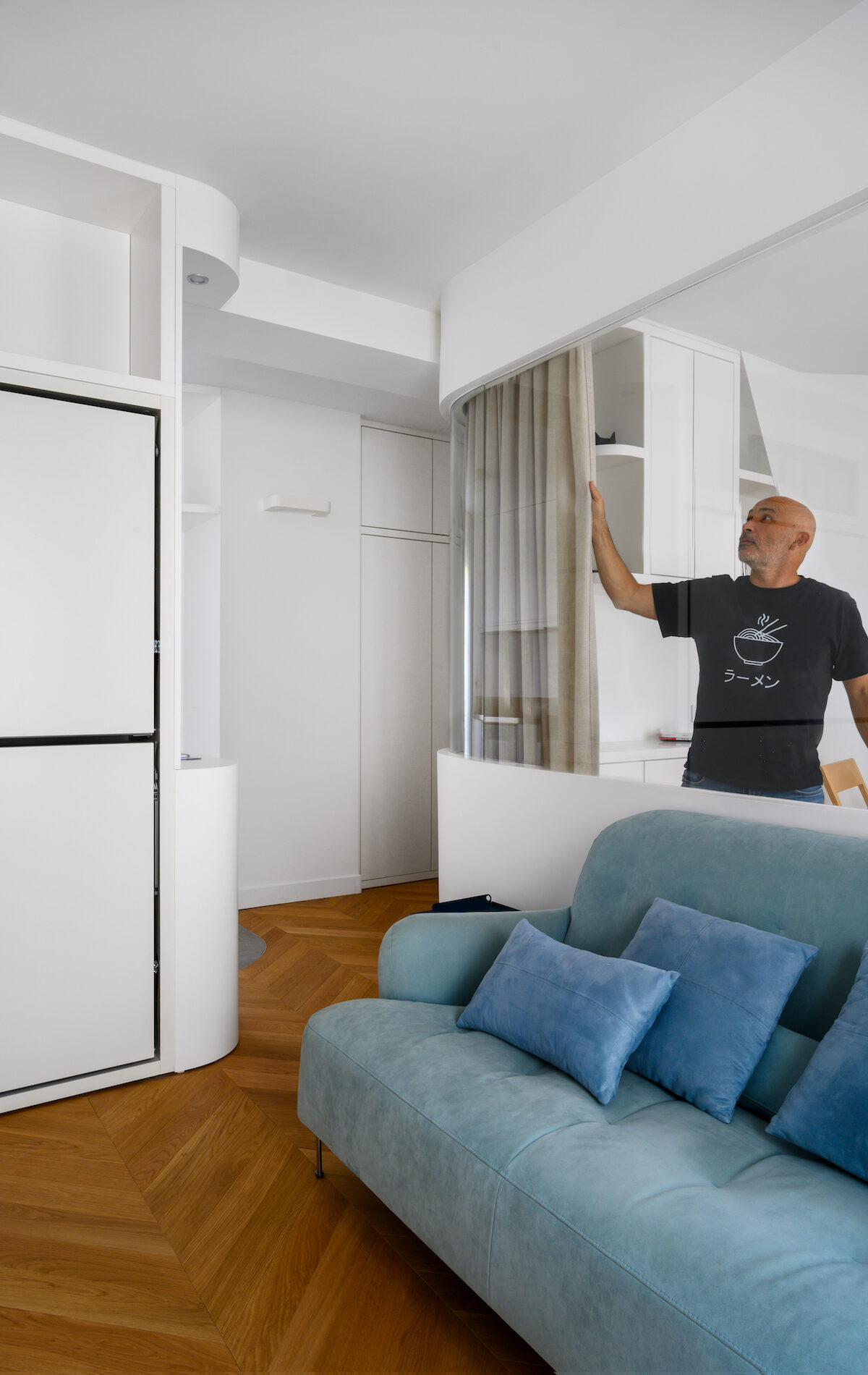 Baie vitrée courbe avec rideau ouvert dans un appartement à Paris