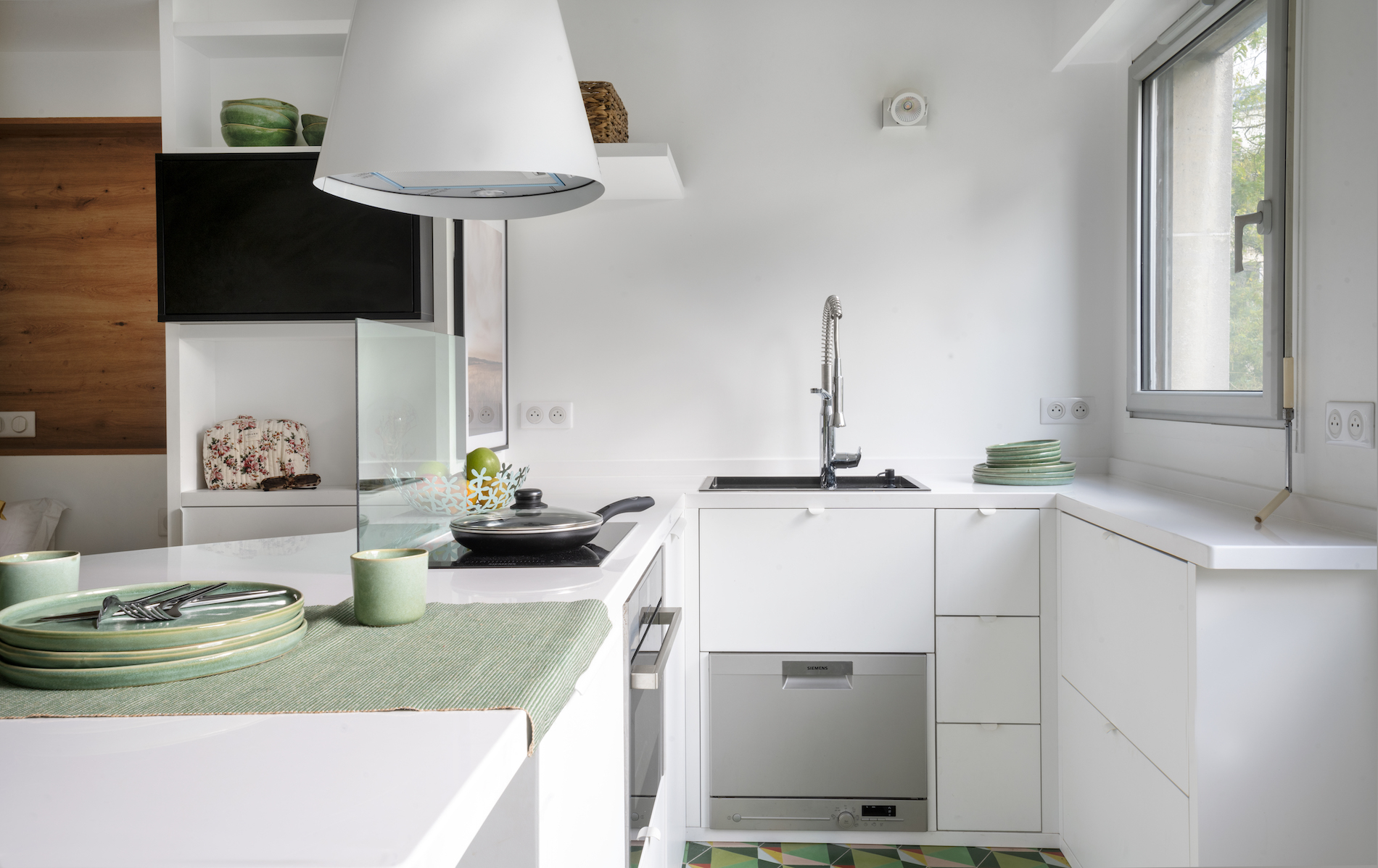 Cuisine compacte blanche avec rangements intégrés dans studio optimisé