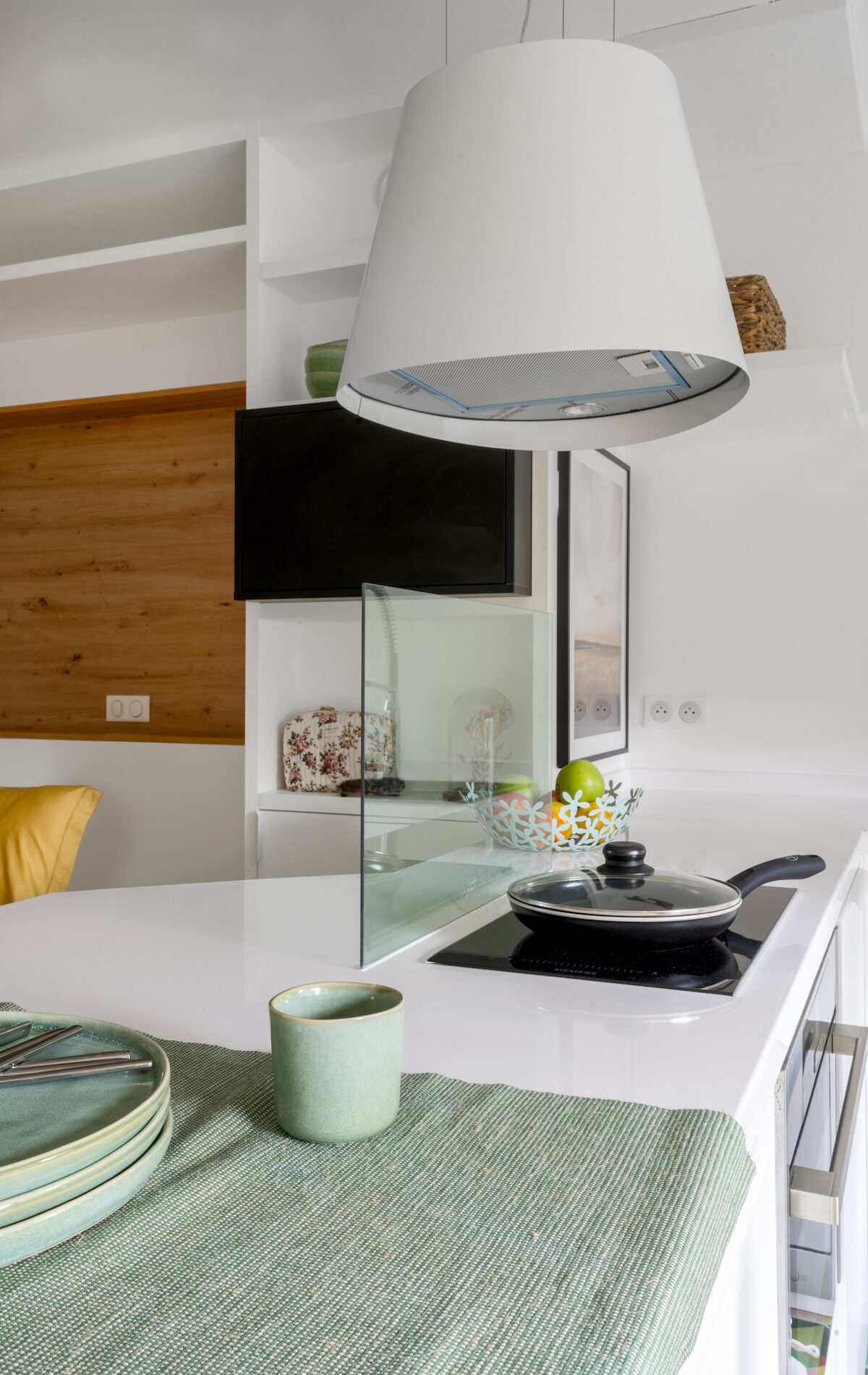 Hotte suspendue design au-dessus d’un îlot dans cuisine compacte